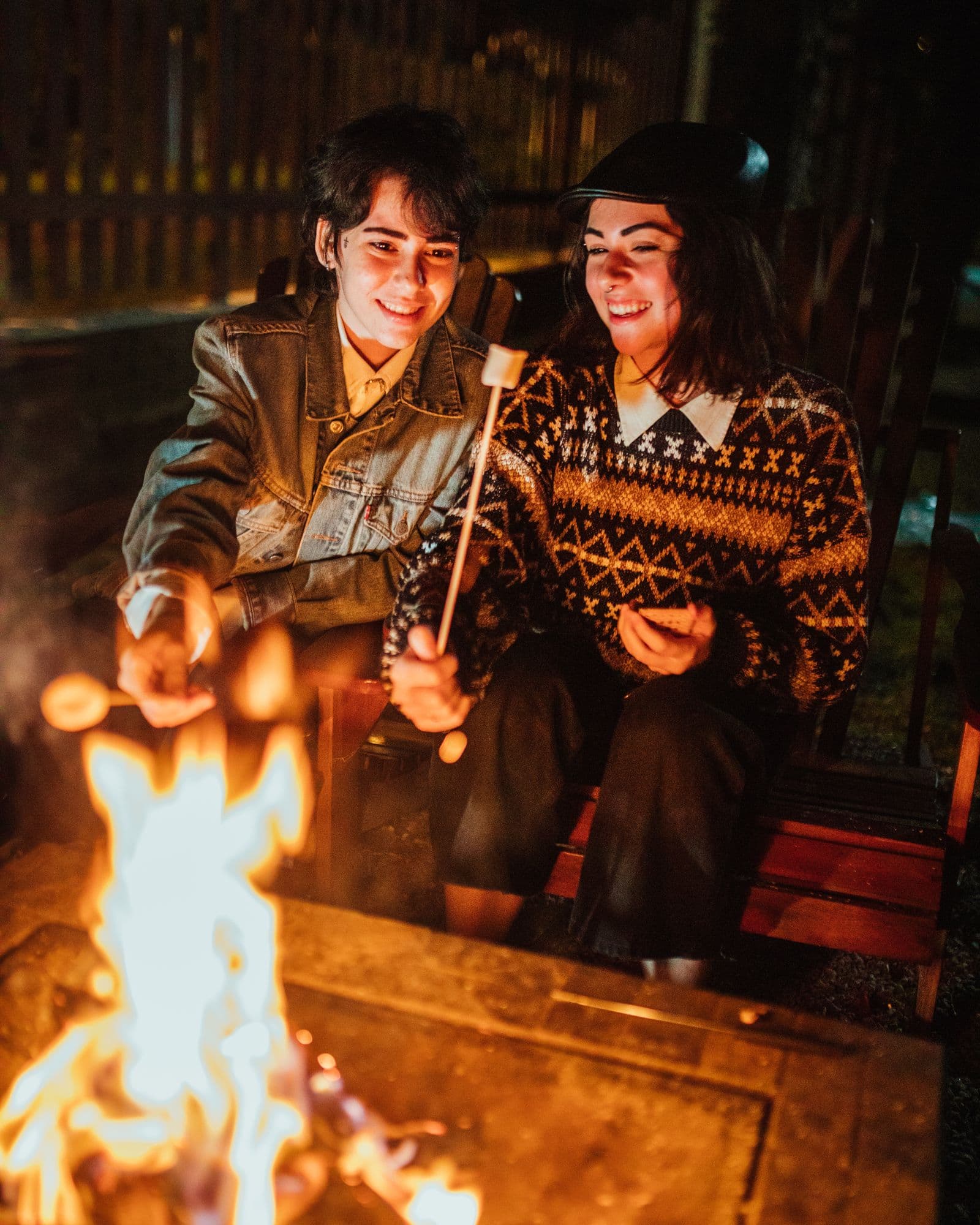 Friends relaxing together by a fire after a day outdoors