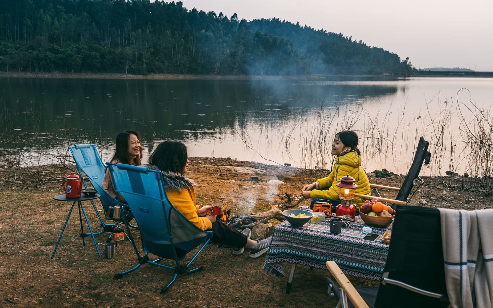 Friends talking together by a lake after a day outdoors