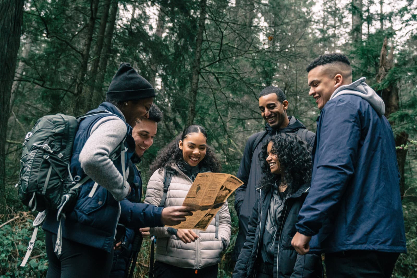 Friends reading a map together in the forest