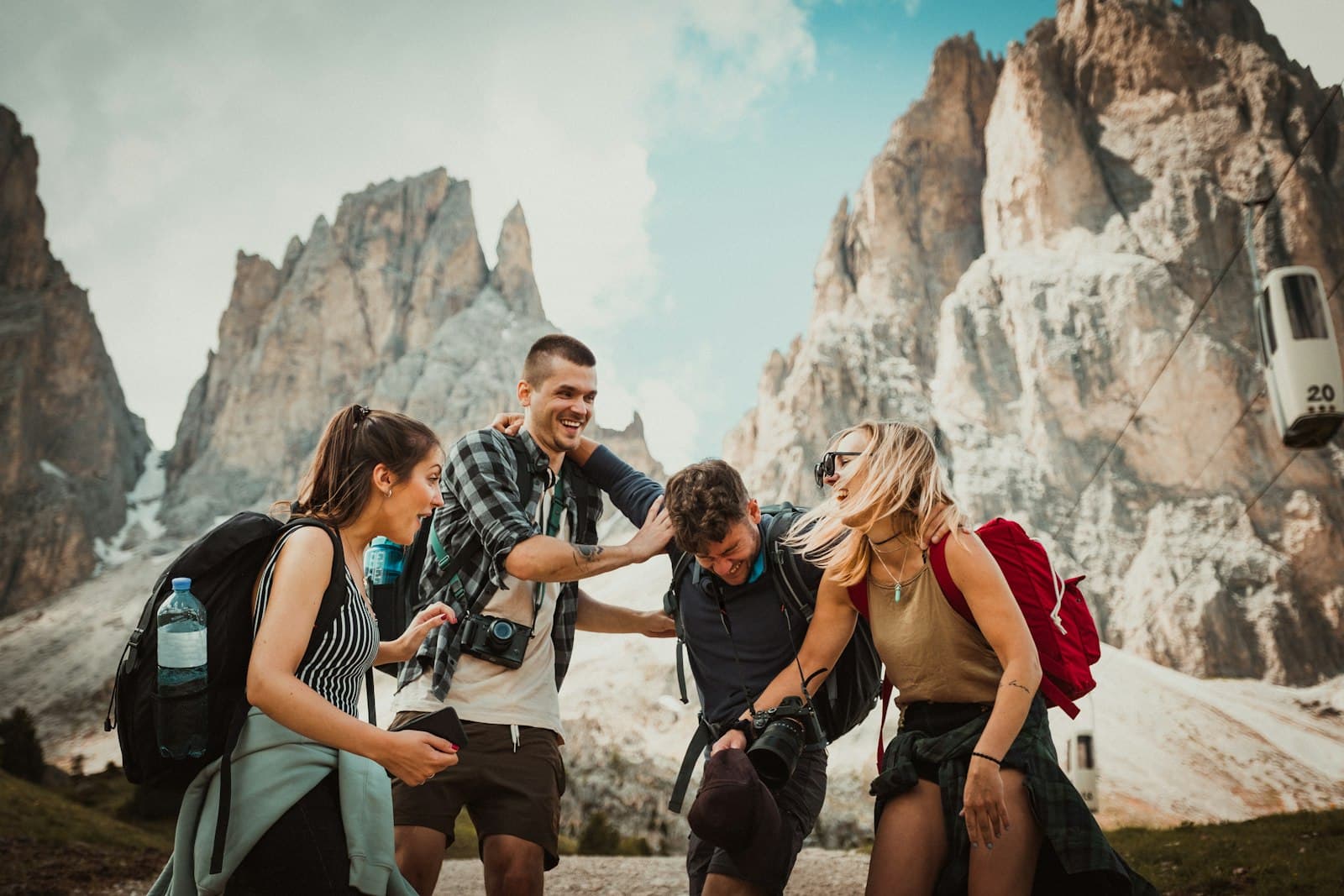 Hikers laughing together on a mountain trail with backpacks